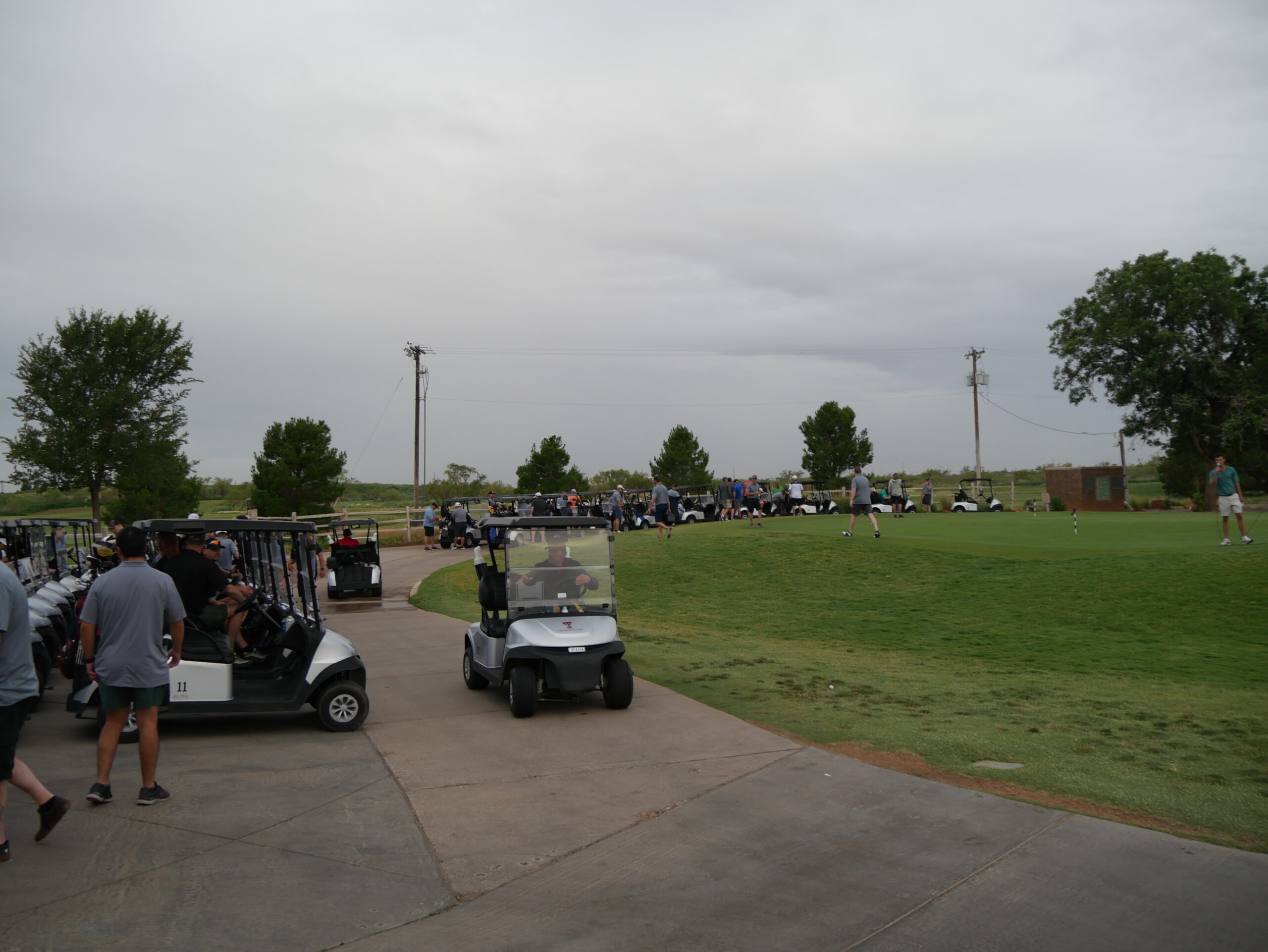 golf carts parked and few being driven by golfers